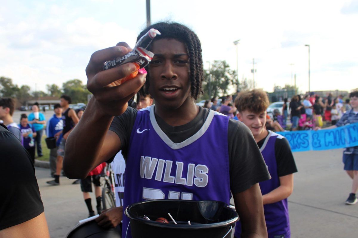 ANYONE WANT CANDY? Showing her candy off, sophomore Timyere Williams walks with the basketball float during the homecoming parade.