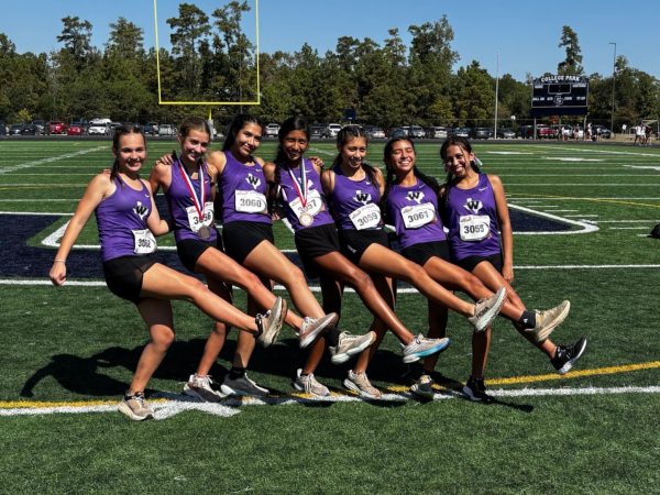 FANCE FEET. Celebrating their regionals berth, the girls cross country team act silly after the district meet on Thursday. 