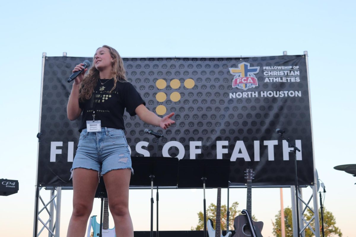 FIELDS OF FAITH. Leading part of the service at Fields of Faith, senior Tori Van Schuyver shows her love of God during the annual event.