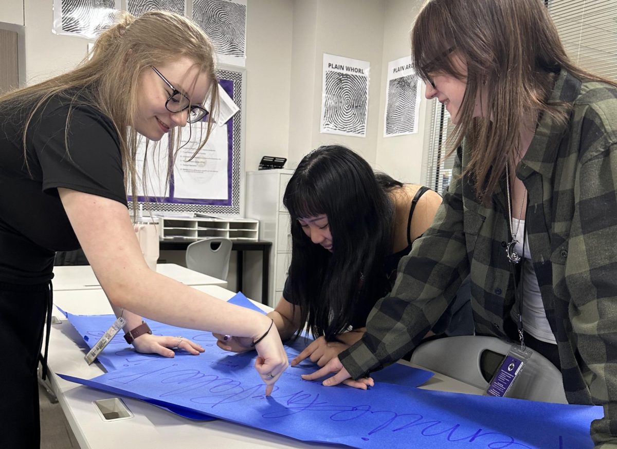 MAKING A DIFFERENCE.  Making signs for Pennies for Polio, Brooke Owsley joins other Interact members during a meeting.