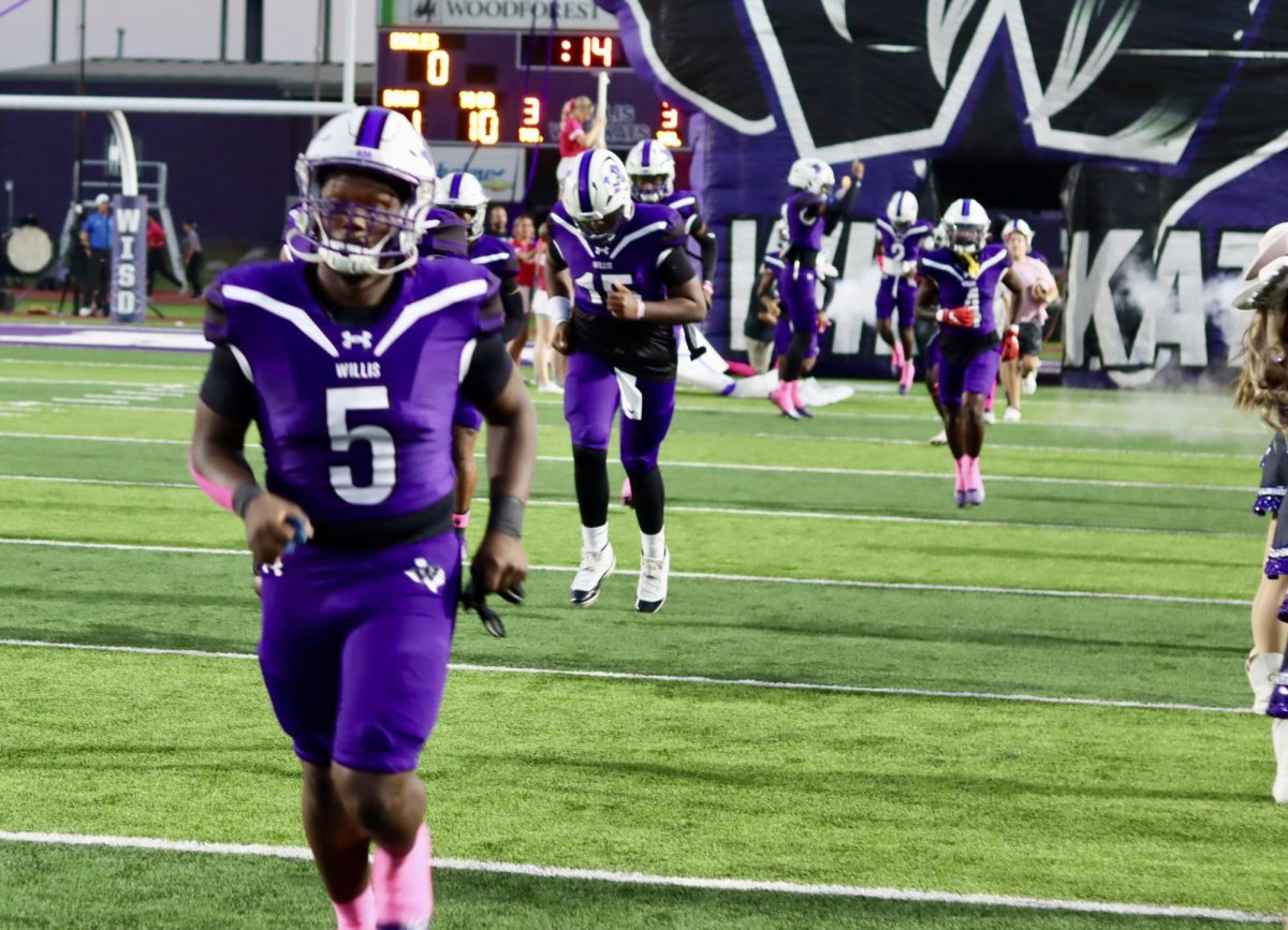 GOOD UNDER PRESSURE. Before the start of the game against New Caney, senior Terri Lawrence takes the field with his fellow Wildkats. Lawrence had 171 yards in the game including rushing, passing and kick off return. He also made a touchdown against the Eagles.