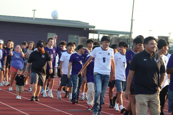 READY FOR A NEW START. At Meet the Kats, Coach Chance Young and his son walk with members of the soccer team before they are announced. Young was promoted to head coach after spending several years as head JV coach.