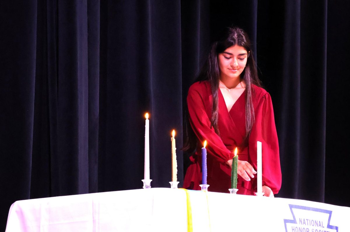 FOUR PILLARS.  During the NHS induction ceremony senior Alyssa Rodriguez lights her candle. Each candle stands for the pillars of leadership, scholarship, service and character.