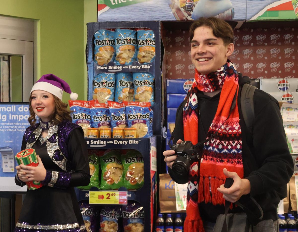 HELPING HANDS. Collecting food and donations for TLC Food Pantry in Willis, juniors Annabell Smith-Grimm and Peter Wetsch volunteer at Kroger Market Place on Friday. Organizations including Sweethearts, yearbook, newspaper and volleyball spent time at the grocery store to help the local food pantry stock up for the holidays. photo by Ella McDonald