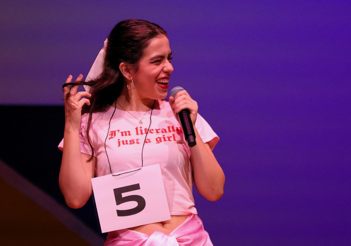 PRETTY IN PINK. Trying to spell a word correctly, senior Ava Foster, a member of the chorus, gives her best guess. 