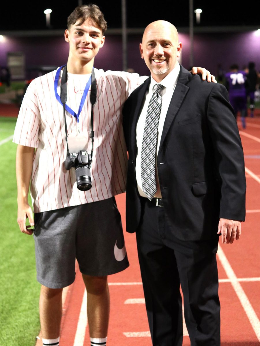 HOCO FUN. One the sidelines of the homecoming game, junior Peter Wetsch joins Principal Eric King.  nAs a member of the yearbook staff Wetsch was able to enjoy Friday Night Lights of the sidelines taking photos.