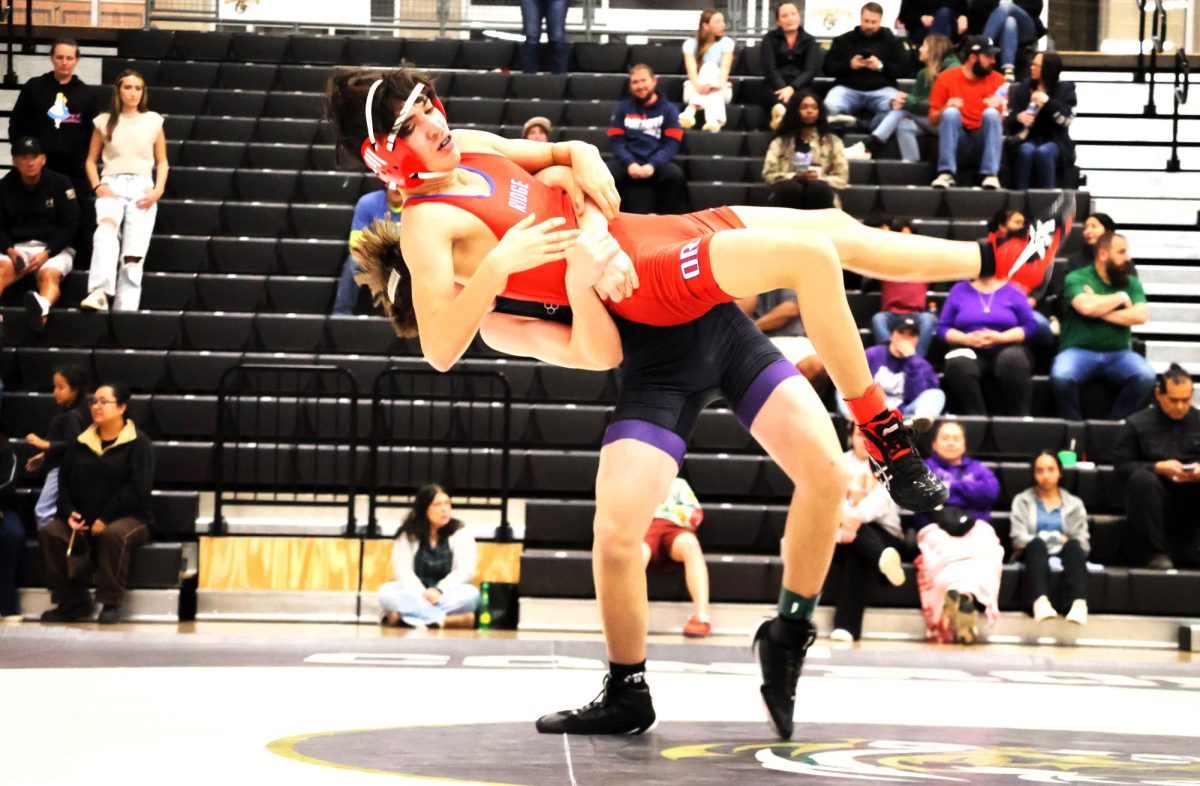 FLYING. Sending his opponent from Oak Ridge to the air, sophomore Wesley Burns uses his strength to make a move at  the compettion at Conroe High School. The wrestling team competed in a tri against the Togers and War Eagles.