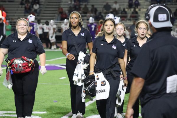 ALWAYS READY. A group of trainers leave the field after a trip to the field during a timeout. 