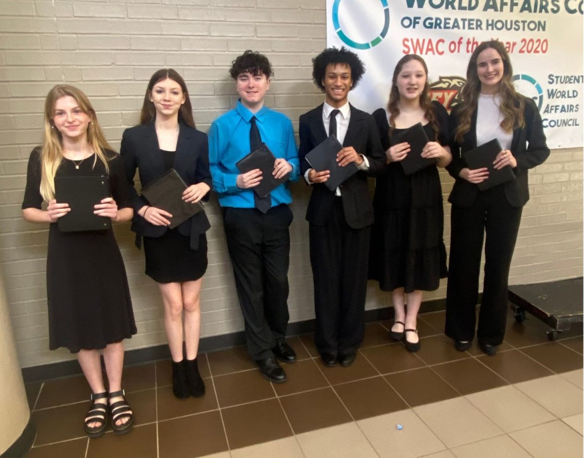 SHARP DRESSED TEAM. Before delivering their first round performance, freshman Ella Kouba, freshman Anne Marie Carman, freshman Carter Bernard, junior Isaiah Higgins, senior Danica Sundquist and freshman Alyssa Dennis take a quick picture.