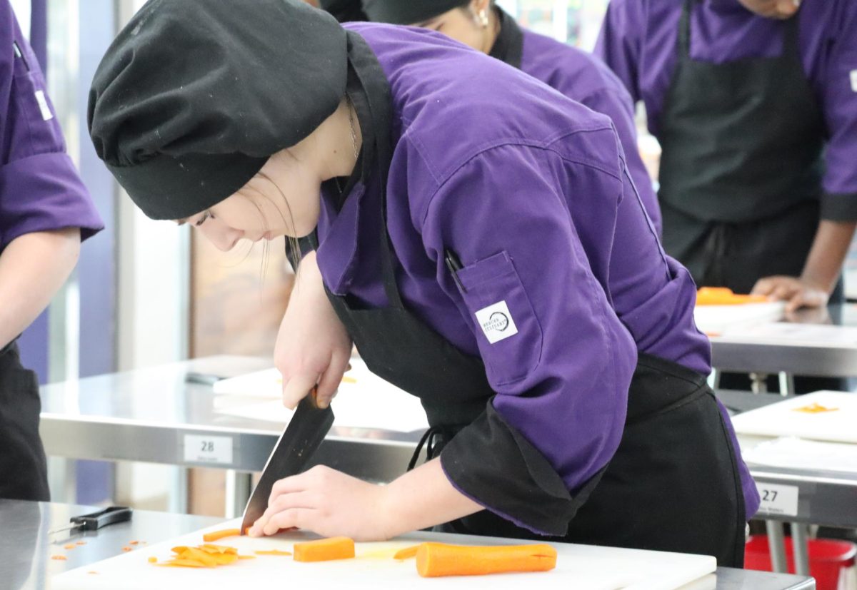 CHOP CHOP. In advanced culinary class, junior Addie Thomson works on her knife skills chopping carrots. photo by Finley McDonald