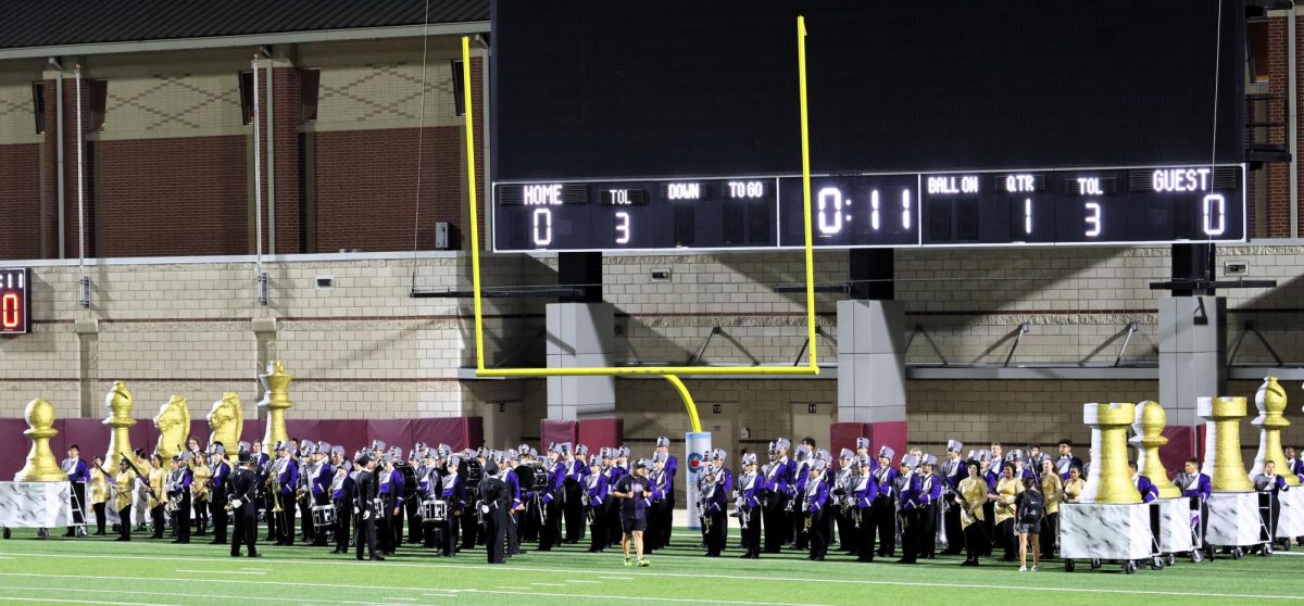 ON THE LINE. Waiting to show off months of hard work, the band gathers in the end zone before the contest. Success in the contest meant qualifying for area.