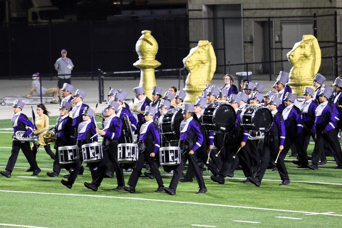 MAKING MOVES. The band and their chess piece proms march on the field for UIL contest. All three judges awarded the band ones for their performance.