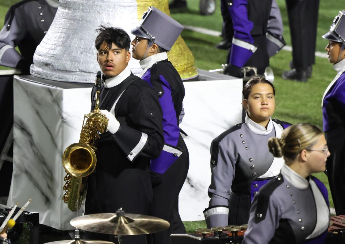 LOCKED IN. Watching his fellow drum major during the show, junior Nicolas Osorio concentrates.  