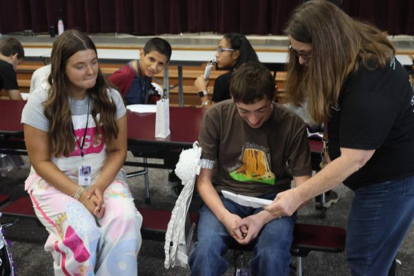 SENIOR HOCO. Enjoying his letter and garter, senior Preston Seay listens as STRIDE instructor Michelle Brown reads the letter senior Kamryn Smith included with her gift of a garter for Seay to wear. 