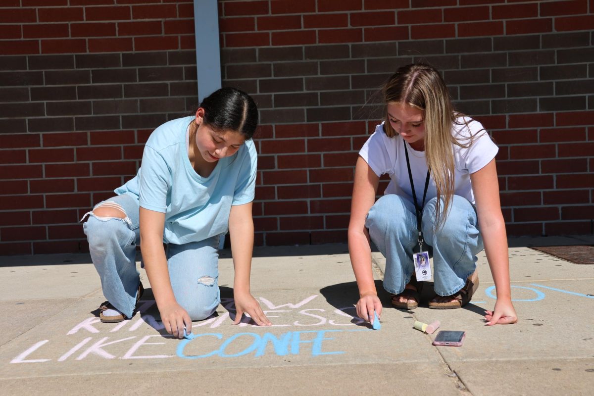 THROW KINDNESS LIKE CONFETTI.  Working on the club's first project, juniors Yajaira Tapia and Ashtyn King fill the side walk by the gym with kind messages with the Balancing Bridge Club. The club is new on campus and its goal is to promote mental health within the Wildkat community. photo by Victoria Medina