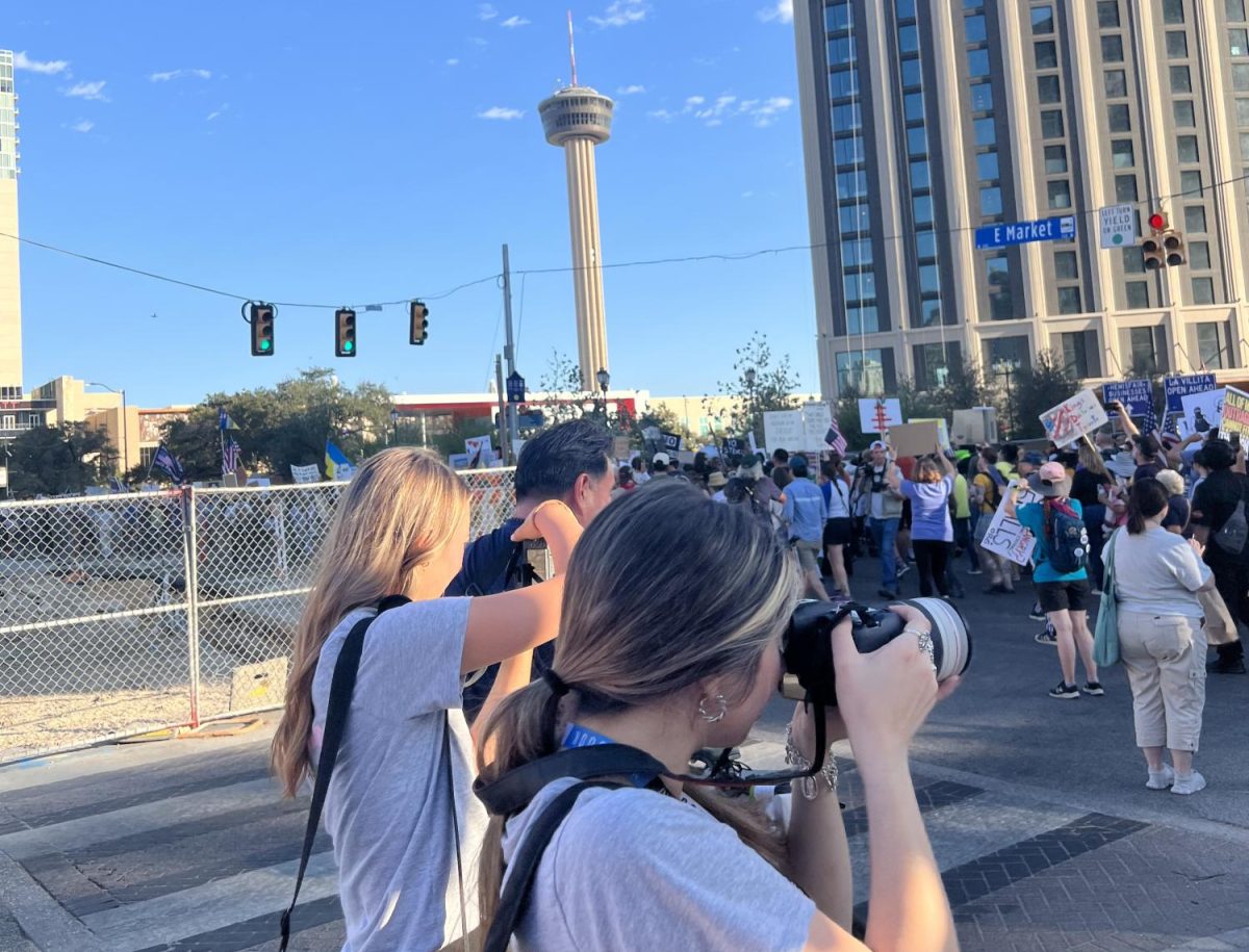 JOURNALISTS IN ACTION. Documenting a No Kings protest in San Antonio, junior Ashtyn King and senior Victoria Medina take photos. The student journalists were in San Antonio attending the TAJE state convention.