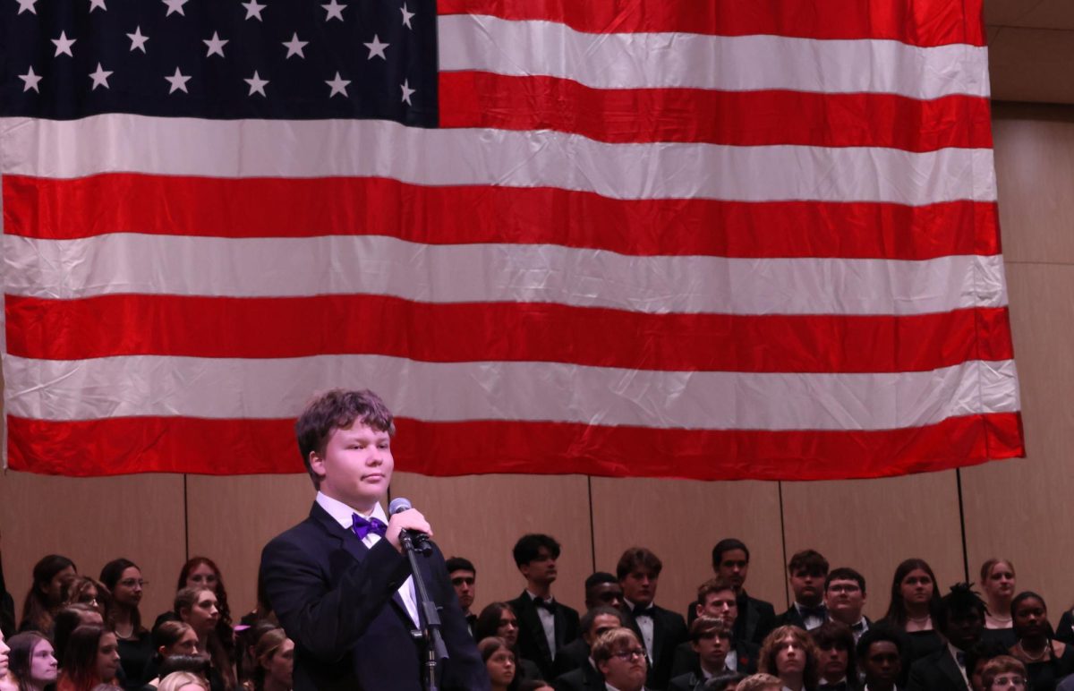 STARS AND STRIPES. During the choir's Veteran's Day concert freshman Daniel Vick sings to the crowd. The choir joined with the WISD Elementary Honor Choir to honor veterans for their service. 