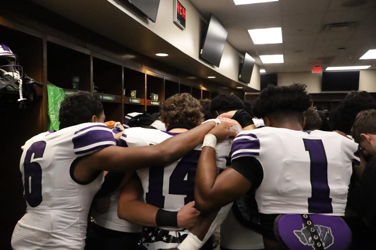 LET US PRAY. Before the game, the Wildkats gather together for a moment of prayer in the locker room.
