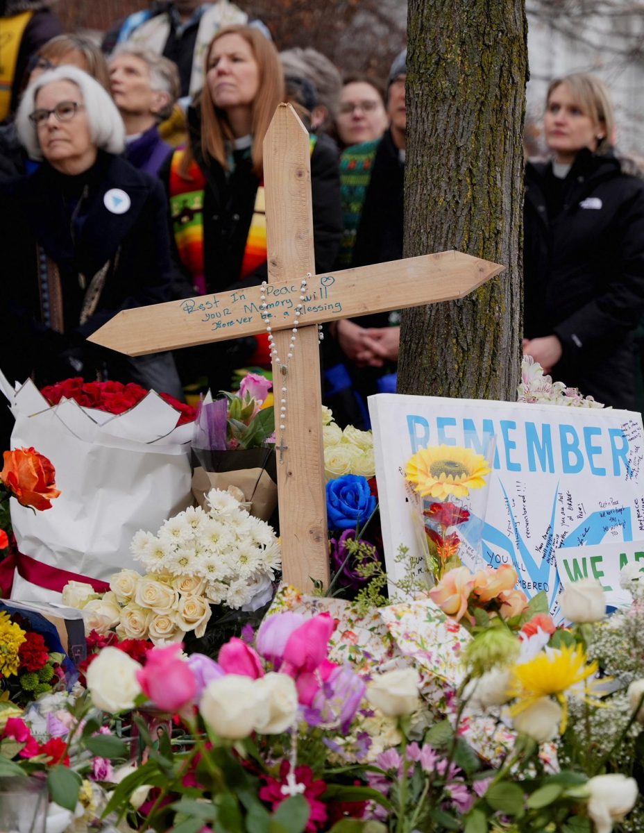 A cross and flowers sit at a makeshift memorial at the scene of the fatal shooting of Renee Nicole Good by a U.S. Immigration and Customs Enforcement (ICE) agent, in Minneapolis, Minnesota, U.S., January 8, 2026. REUTERS/Tim Evans
