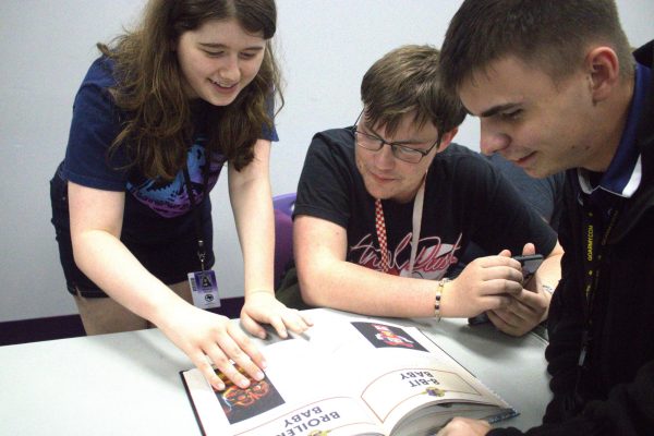 CAMARADERIE. Sophomore Madison Vercell joins juniors William Padgitt and Phillip Weeks at an Esports meeting.