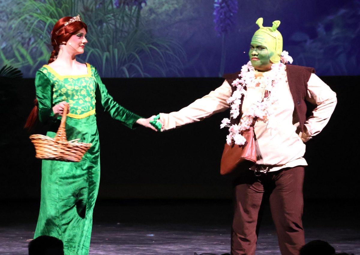 DREAMS COME TRUE. On their trip to Duloc, Fiona (sophomore Sophia Von Kuschembahr) and Shrek (senior Jhun Abarquez) hold hands during their scene. 