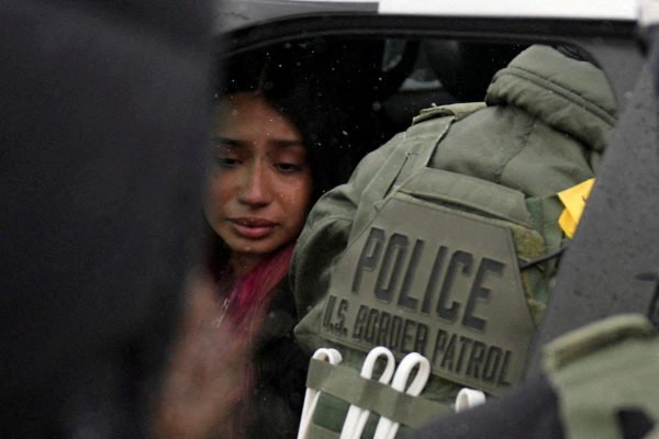 A detained woman sits inside a vehicle surrounded by federal agents, as immigration enforcement continues after a U.S. Immigration and Customs Enforcement (ICE) agent fatally shot Renee Nicole Good on January 7 during an immigration raid, in Minneapolis, Minnesota, U.S., January 21, 2026. REUTERS/Leah Millis
