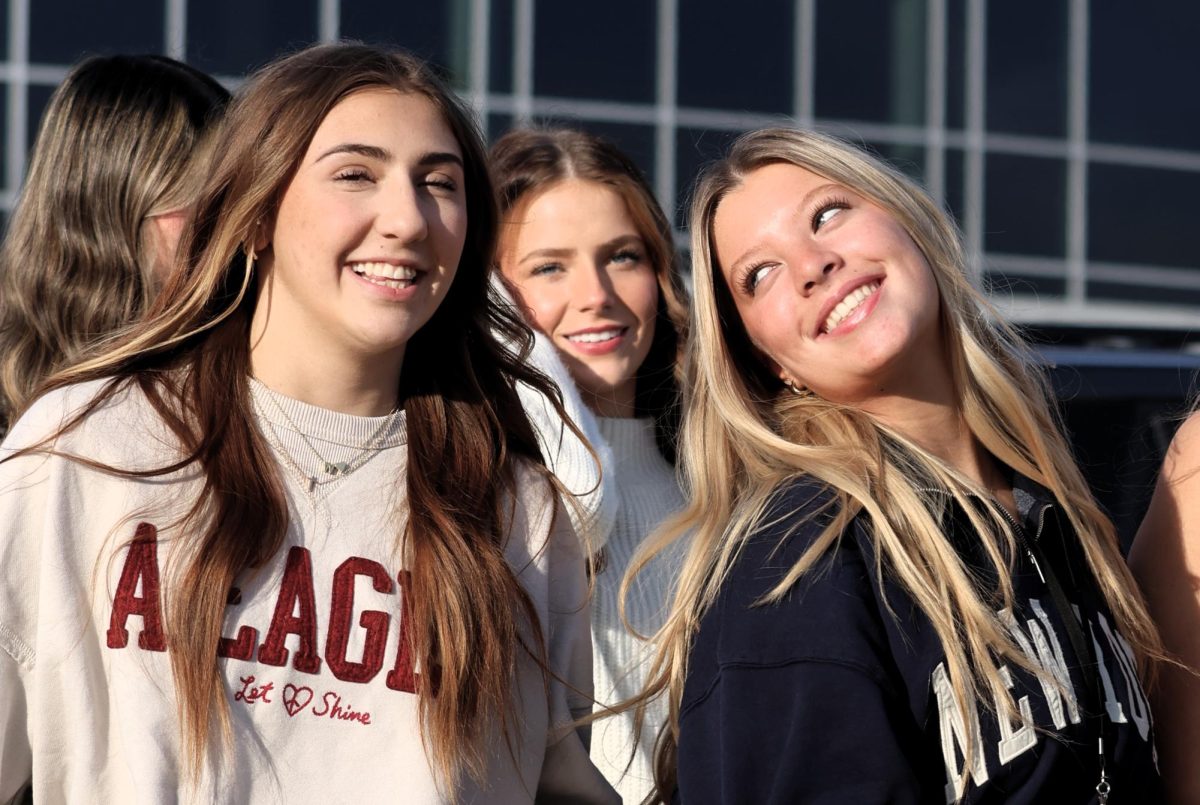 TOO GOOD TO BE TRUE. Walking to the senior panoramic picture, seniors Mikayla Baird and Maddie Mae Bratton share a moment of friendship. Photo by Tucker Chapman