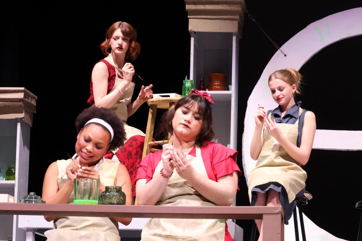 LICK AND DIP. Being paid by their production, Charlotte Purcell (senior Avalon Barretto) Francis O'Connell (junior Emma Johnston) and Pearl Payne (sophomore NaLani Washington) paint with their coworkers sophomores Sophia Von and Ella Kouba. 